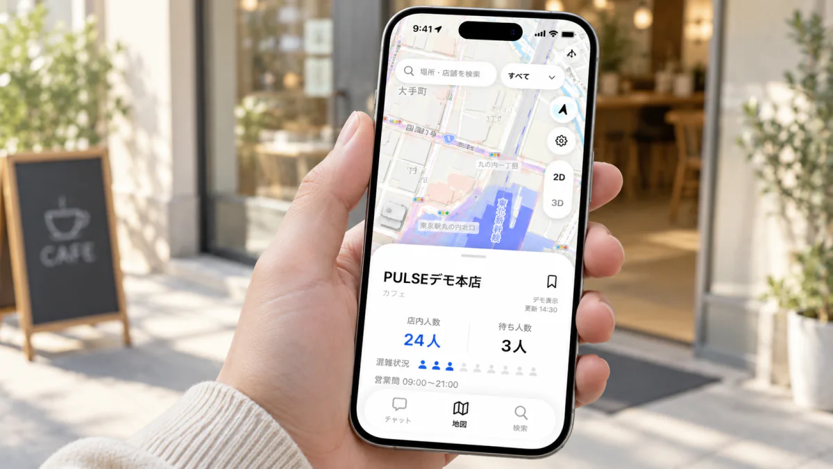 カフェの前で手に持ったiPhoneに、PULSEの店舗ページ。店内人数24人、待ち3人。